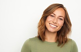Woman in green shirt with brown hair smiling