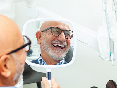 A man looking in the mirror at his smile
