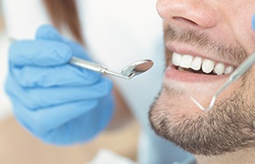Man with dental implants in Beverly, MA receiving dental checkup