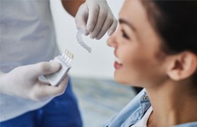 A dentist holding clear aligners for a patient