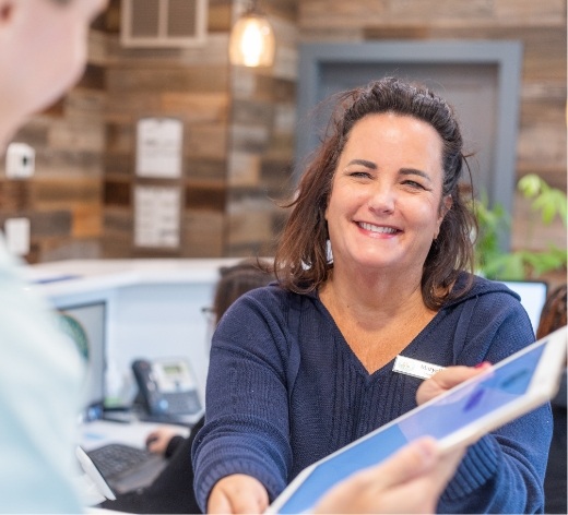Dental team member talking to dentist with tablet
