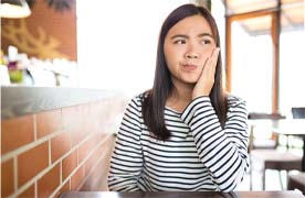 Woman with toothache in Beverly pondering in a restaurant