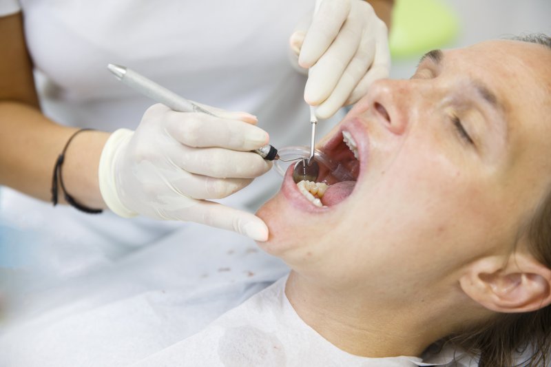 woman mouth open receiving dental treatment