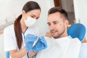 dentist holding Invisalign talking to patient 
