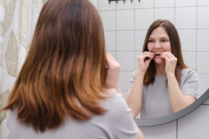 woman putting on Invisalign aligner