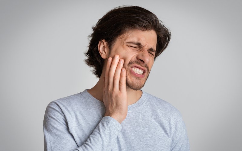 A grimacing man suffering from tooth pain